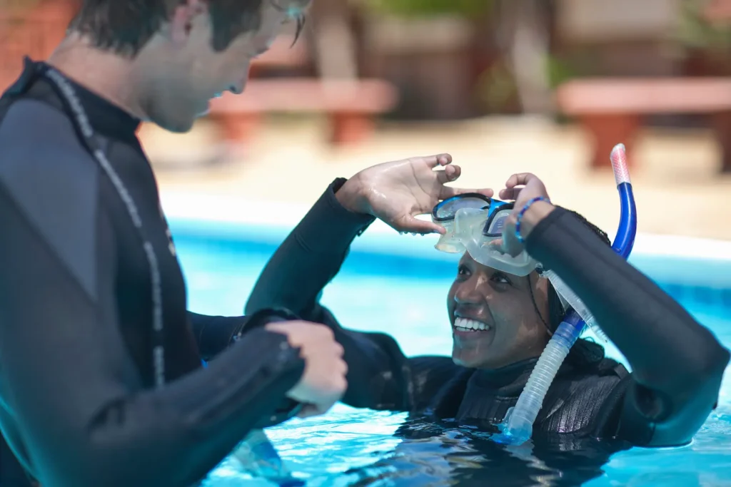 Instructor de buceo con alumna en clase de buceo